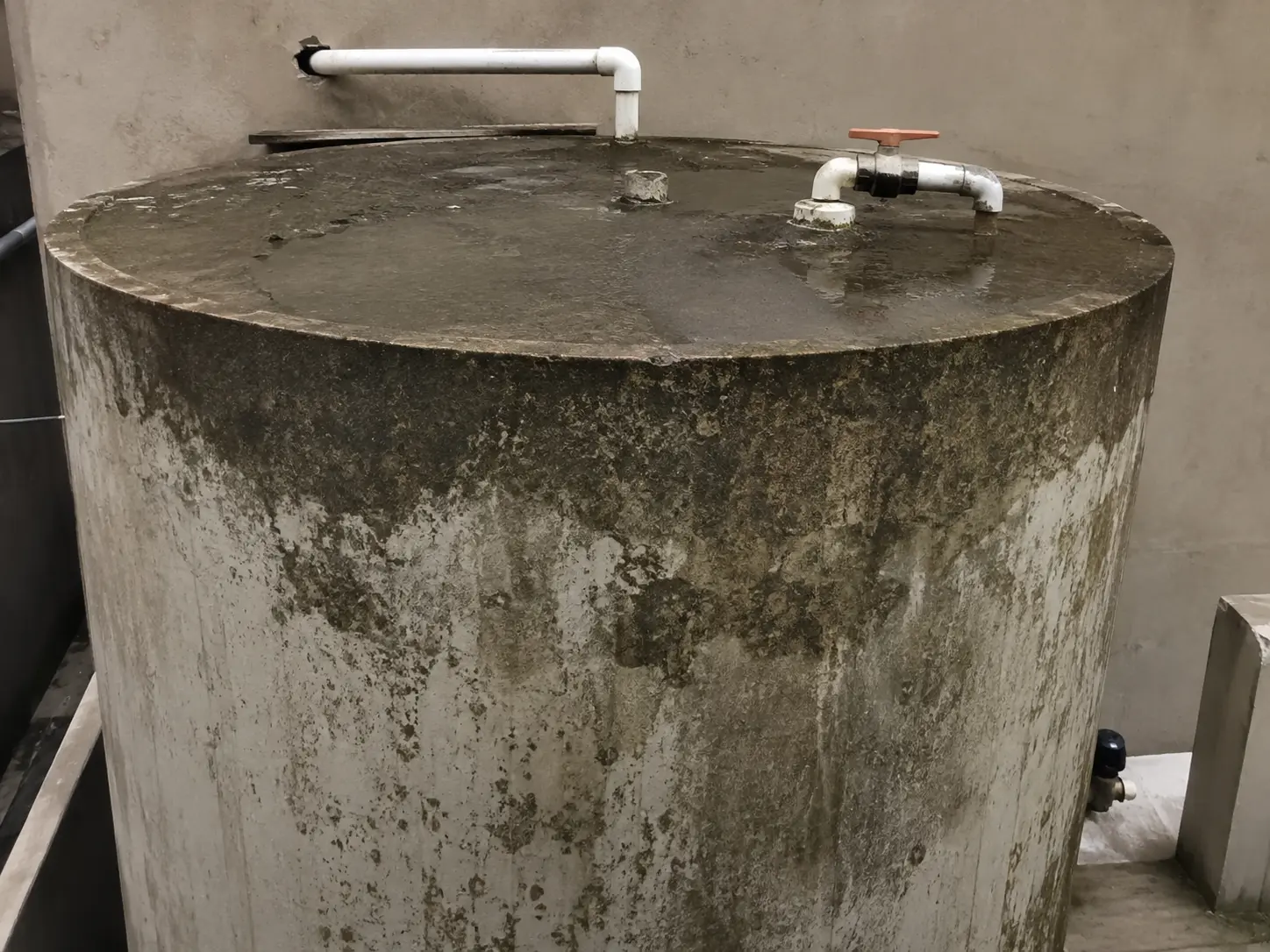 Water tank in Islamabad before cleaning, with algae and sludge inside